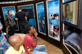 Les personnes qui visitent le nouveau centre d’amélioration de la vie de Scientologie regardent les panneaux multimédias illustrant les croyances et les pratiques de la Scientologie, la vie et le legs du fondateur L. Ron Hubbard, et les programmes d’amélioration humanitaire et sociale de l’Église.